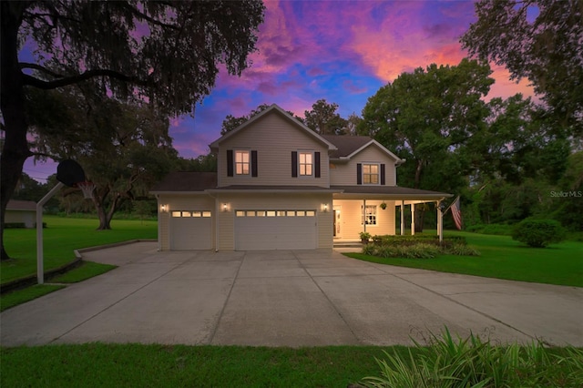 view of front of home with a garage, covered porch, and a lawn