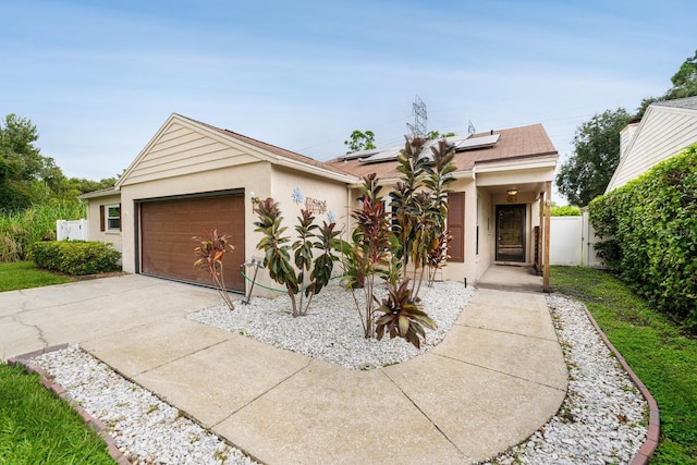 ranch-style home featuring a garage and solar panels