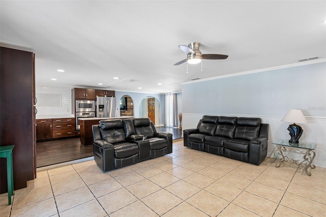 tiled living room featuring ornamental molding and ceiling fan