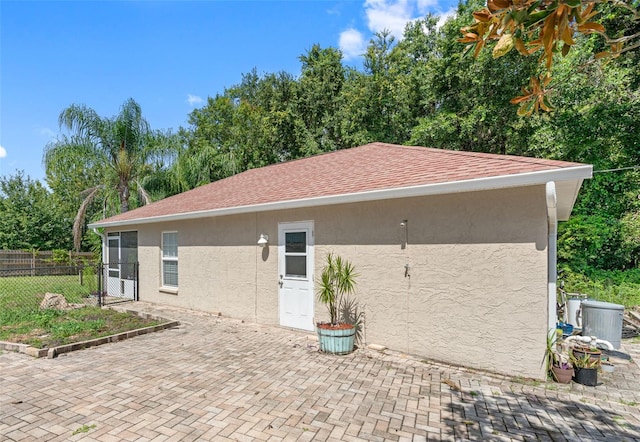 back of house with central AC unit