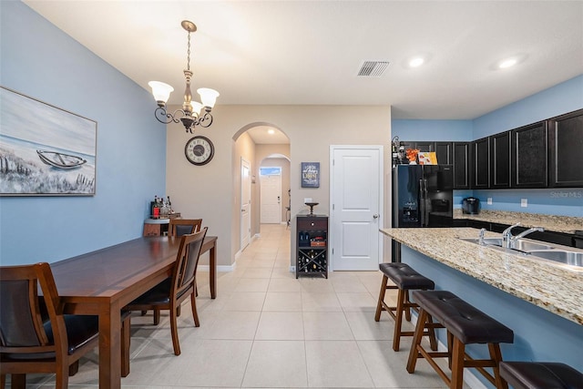 tiled dining area with an inviting chandelier