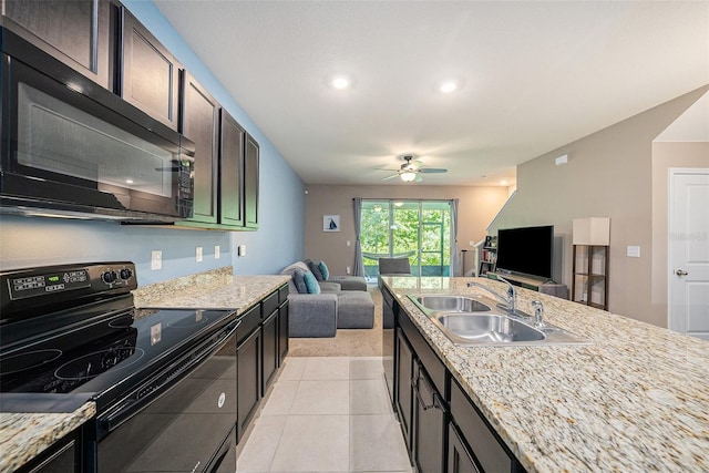 kitchen with sink, black appliances, light tile patterned floors, and light stone countertops