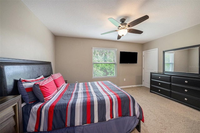 carpeted bedroom featuring a textured ceiling and ceiling fan