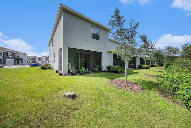 rear view of property featuring a lawn