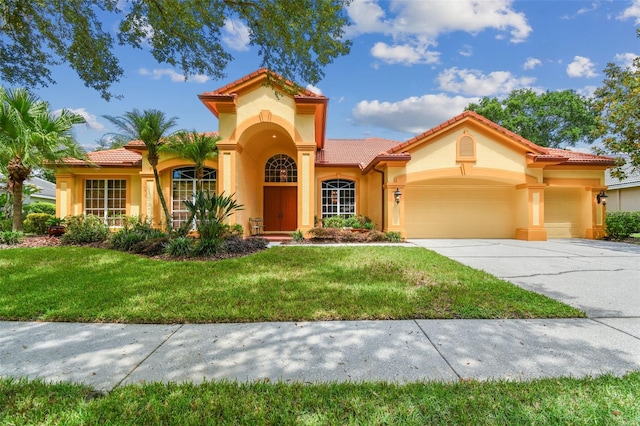 mediterranean / spanish home with a garage and a front lawn