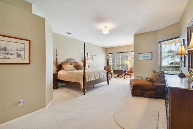 carpeted bedroom featuring multiple windows and a textured ceiling