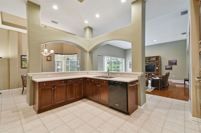 kitchen with a chandelier, a high ceiling, light wood-type flooring, sink, and black dishwasher