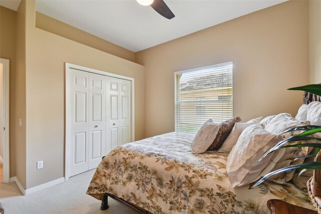 bedroom with light colored carpet, a closet, and ceiling fan