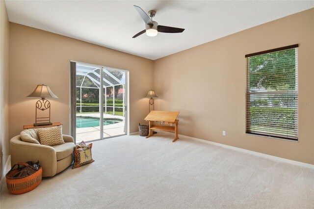 living area featuring carpet and ceiling fan