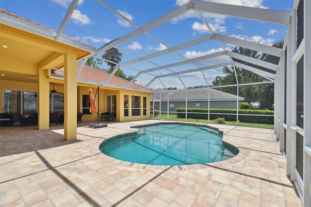 view of pool with a patio and glass enclosure