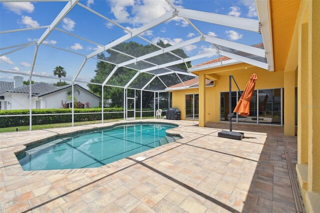 view of swimming pool with a patio area and glass enclosure