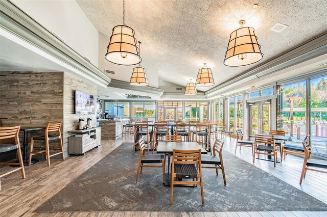 dining area featuring a textured ceiling, wood-type flooring, and a tray ceiling