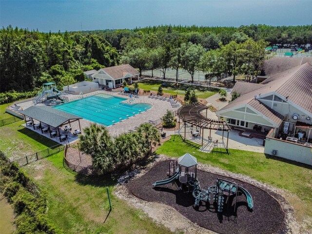 view of swimming pool featuring a patio area, a playground, and a yard