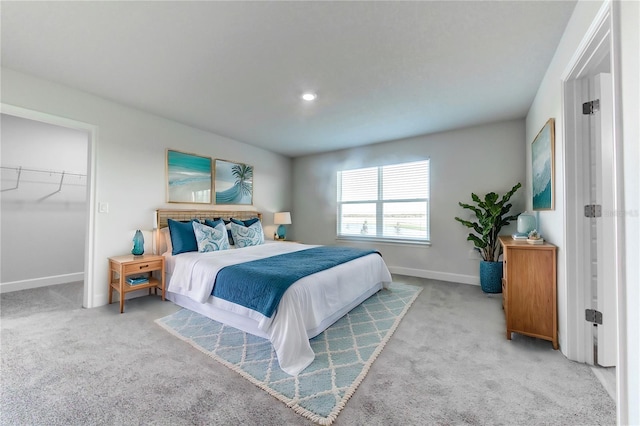 carpeted bedroom featuring a spacious closet and a closet