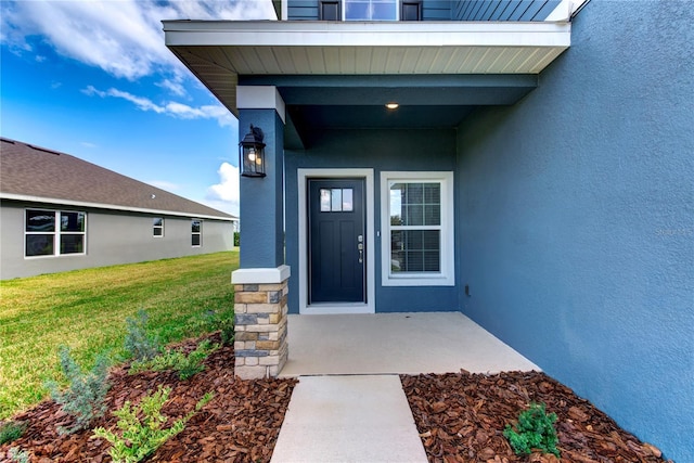 view of exterior entry with a lawn