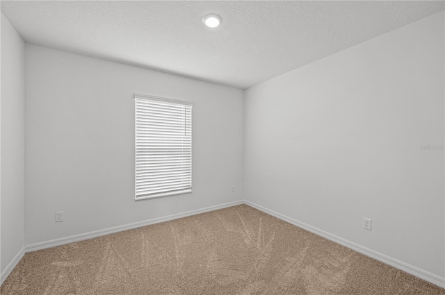 carpeted spare room with a textured ceiling