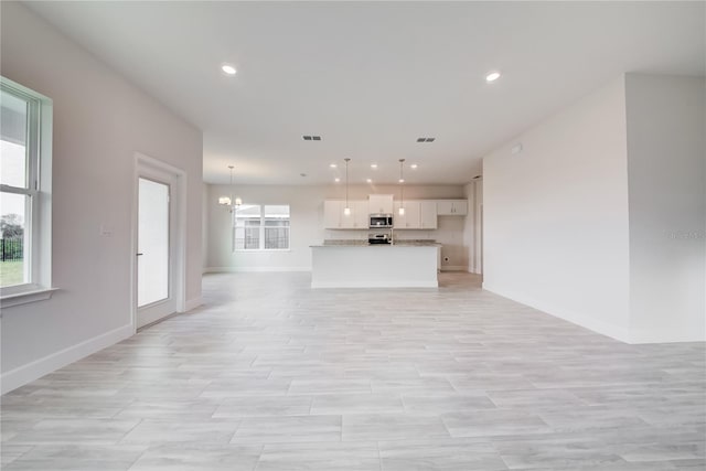 unfurnished living room with an inviting chandelier