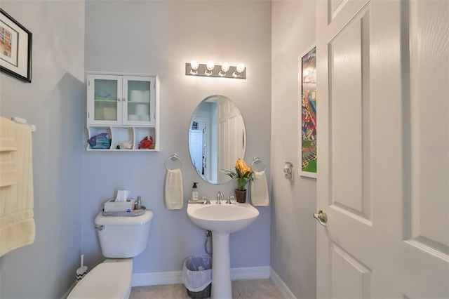 bathroom with sink, toilet, and tile patterned flooring