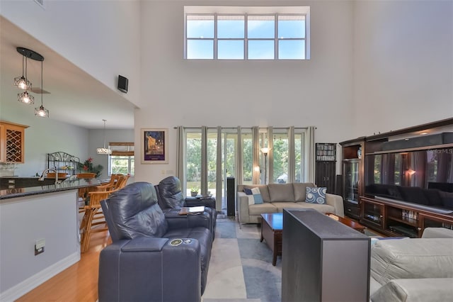 living room featuring a towering ceiling and light hardwood / wood-style flooring