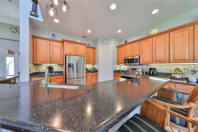 kitchen featuring tasteful backsplash, sink, a breakfast bar area, hanging light fixtures, and stainless steel appliances