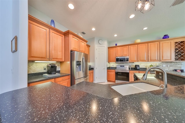 kitchen with appliances with stainless steel finishes, sink, hanging light fixtures, and backsplash