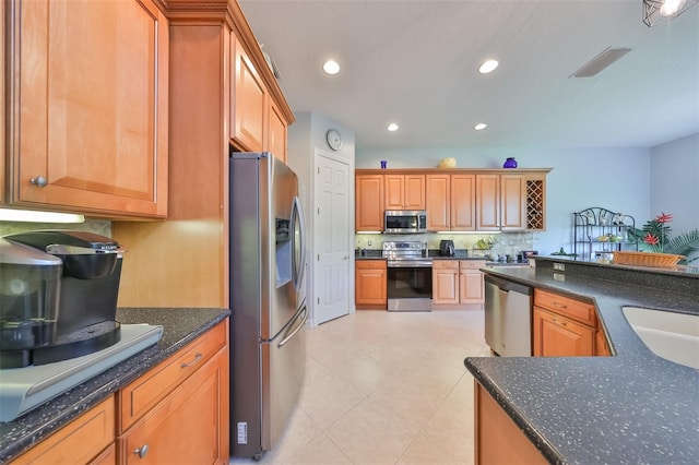 kitchen featuring stainless steel appliances, light tile patterned flooring, and sink