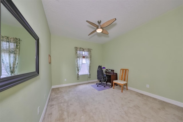 unfurnished office featuring a textured ceiling, light colored carpet, and ceiling fan