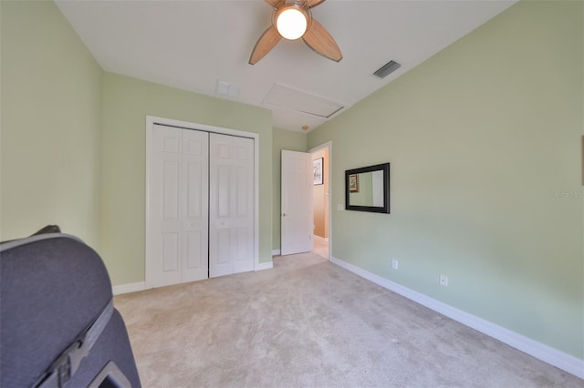 unfurnished bedroom with ceiling fan, light colored carpet, and a closet