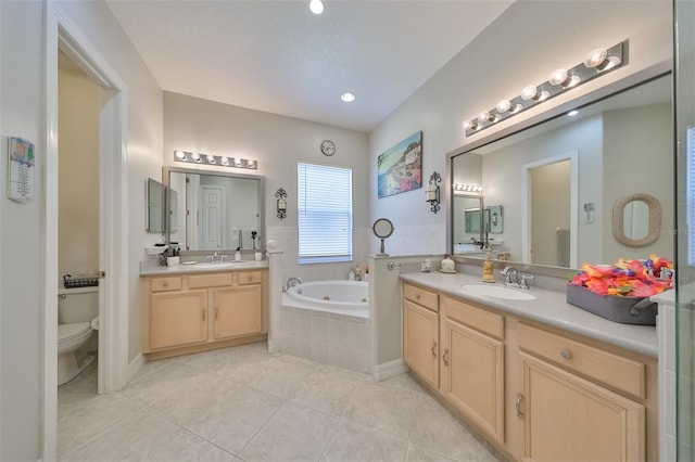 bathroom featuring tile patterned flooring, vanity, toilet, and tiled tub