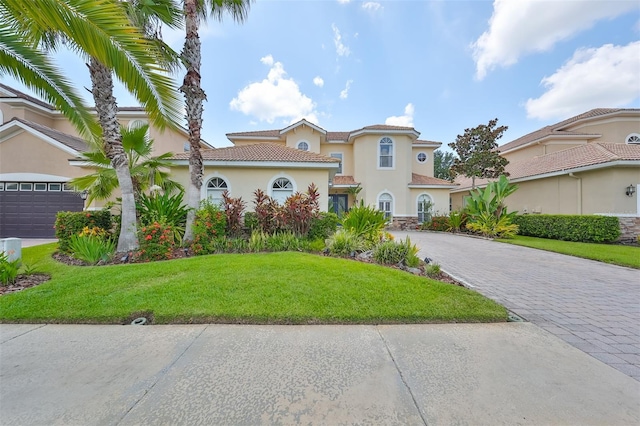 mediterranean / spanish house featuring a garage and a front yard