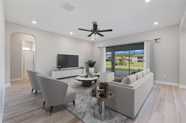 living room with ceiling fan and light hardwood / wood-style flooring