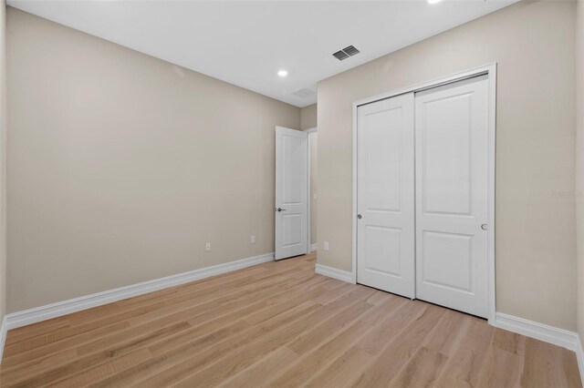 unfurnished bedroom featuring light hardwood / wood-style floors and a closet