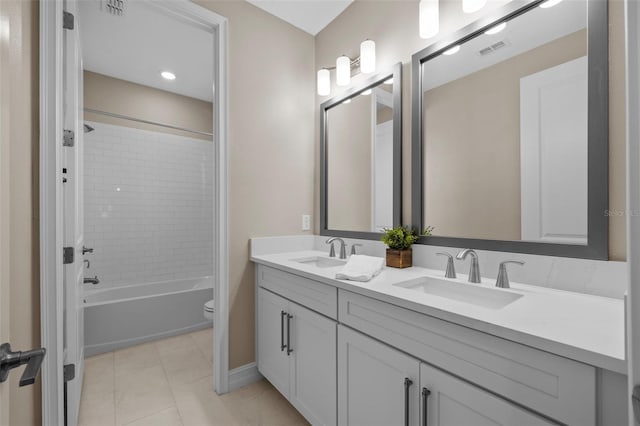 full bathroom with tile patterned floors, tiled shower / bath combo, vanity, and toilet