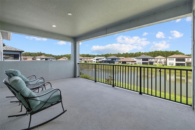 view of patio / terrace with a balcony and a water view