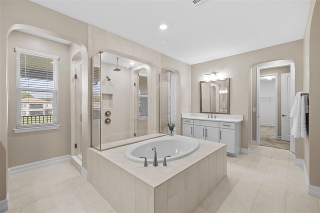 bathroom featuring shower with separate bathtub, vanity, and tile patterned floors