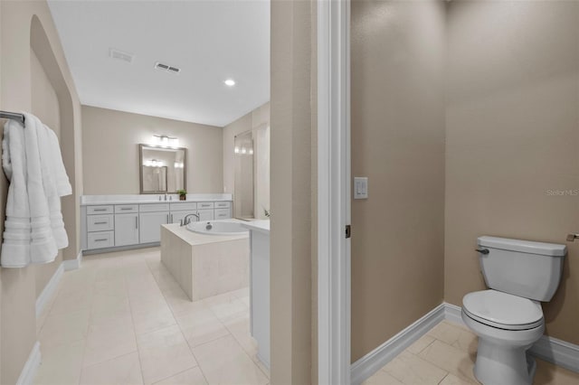 bathroom with tiled tub, vanity, and toilet