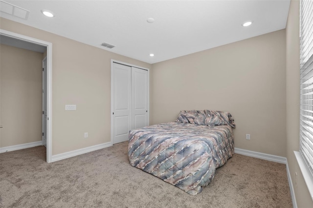 bedroom featuring light colored carpet, a closet, and multiple windows