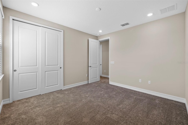 unfurnished bedroom with a closet and carpet floors