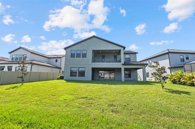 back of property featuring a lawn and a balcony