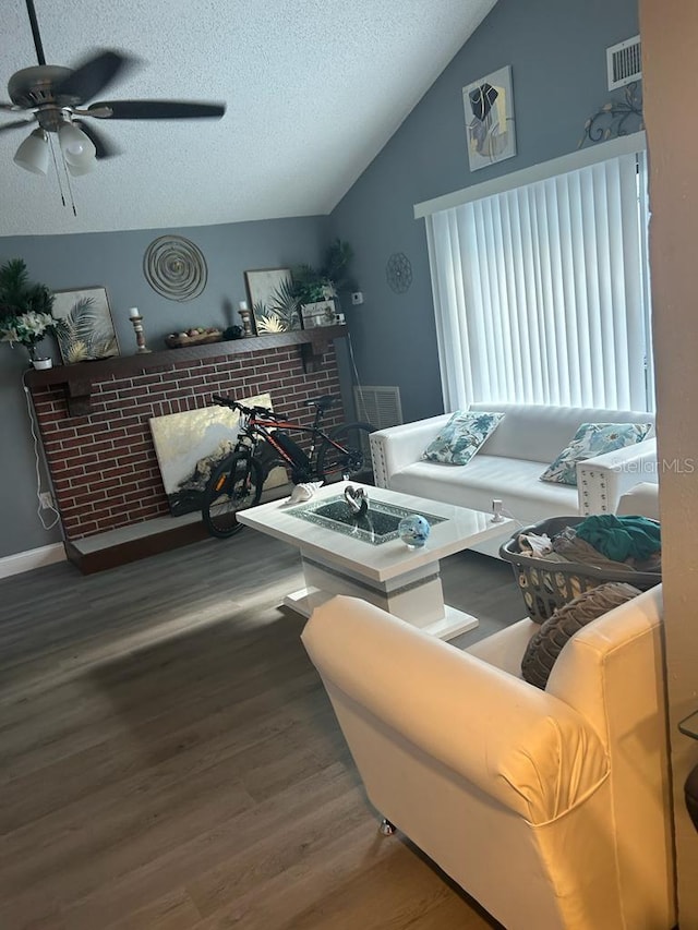 living room with lofted ceiling, wood-type flooring, a textured ceiling, and ceiling fan