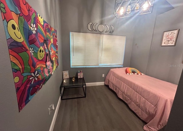 bedroom with baseboards and wood finished floors