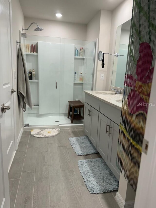 bathroom with walk in shower and vanity