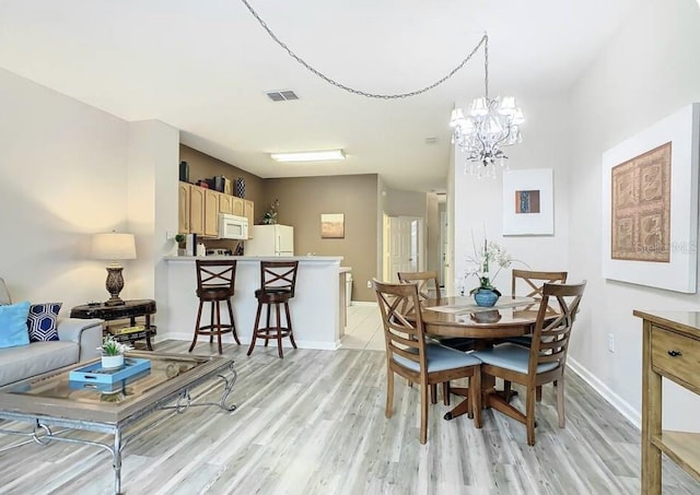 dining area featuring a chandelier and light hardwood / wood-style floors