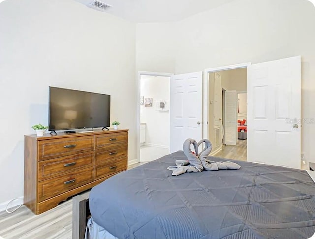 bedroom featuring light hardwood / wood-style flooring and ensuite bath