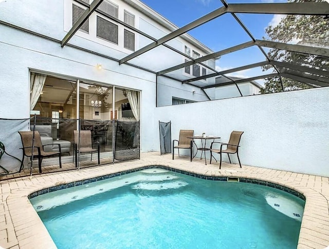 view of pool featuring glass enclosure and a patio area