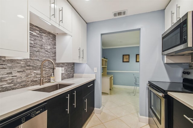 kitchen with sink, light tile patterned floors, white cabinets, and appliances with stainless steel finishes