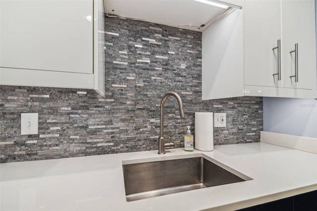 kitchen featuring white cabinetry, sink, and decorative backsplash