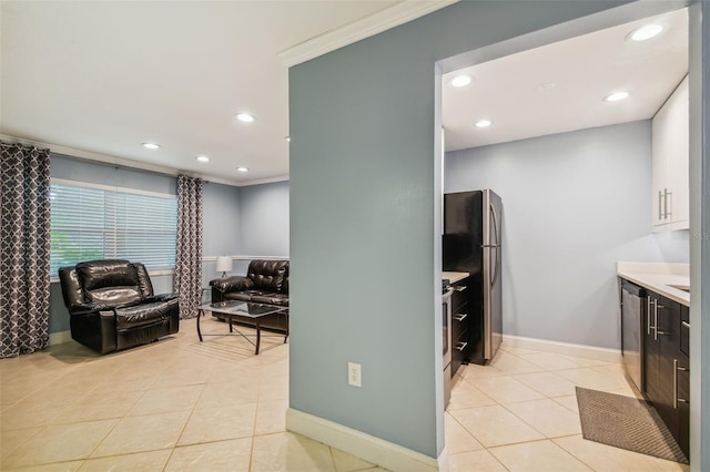 kitchen featuring crown molding, appliances with stainless steel finishes, light tile patterned floors, and white cabinets