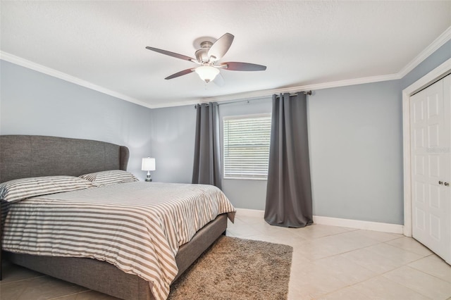 tiled bedroom featuring ornamental molding, ceiling fan, and a closet