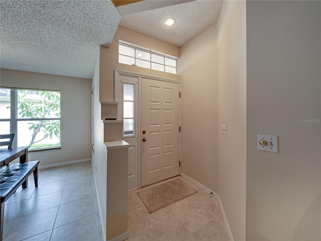 tiled foyer entrance with a textured ceiling